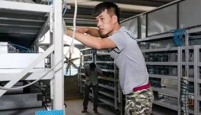 An aerial view of a large-scale mining farm with rows of mining rigs and cooling systems.